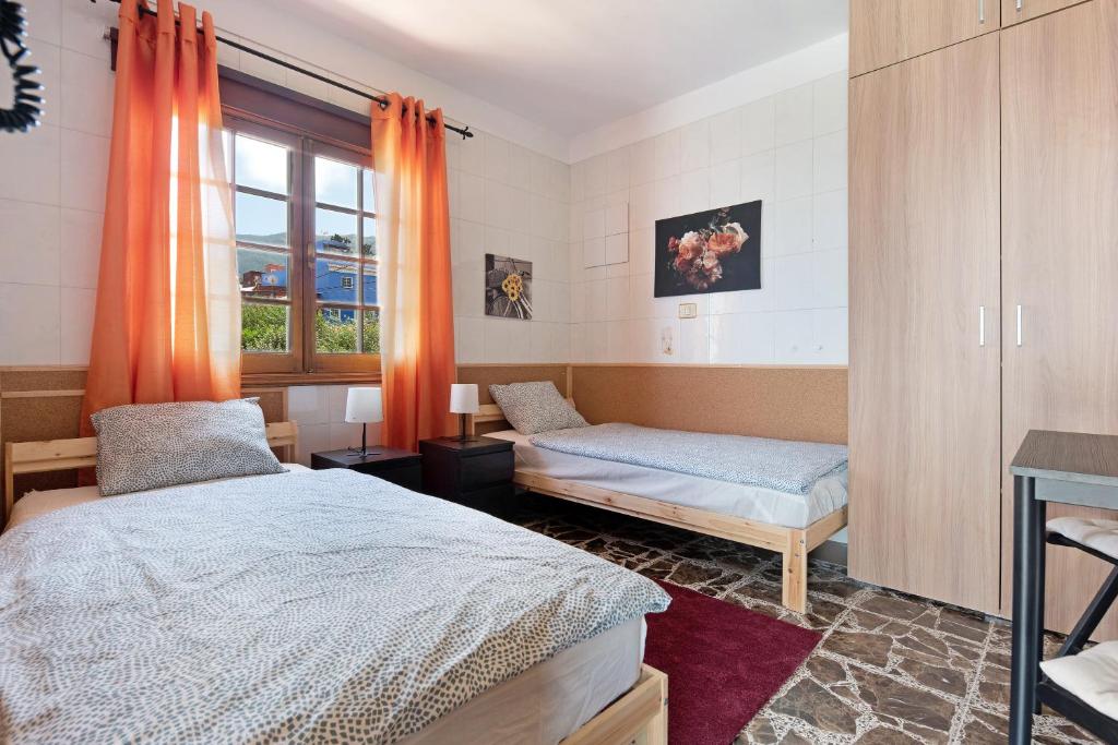 拉奥罗塔瓦House Vochozka的一间卧室设有两张床,窗户配有橙色窗帘