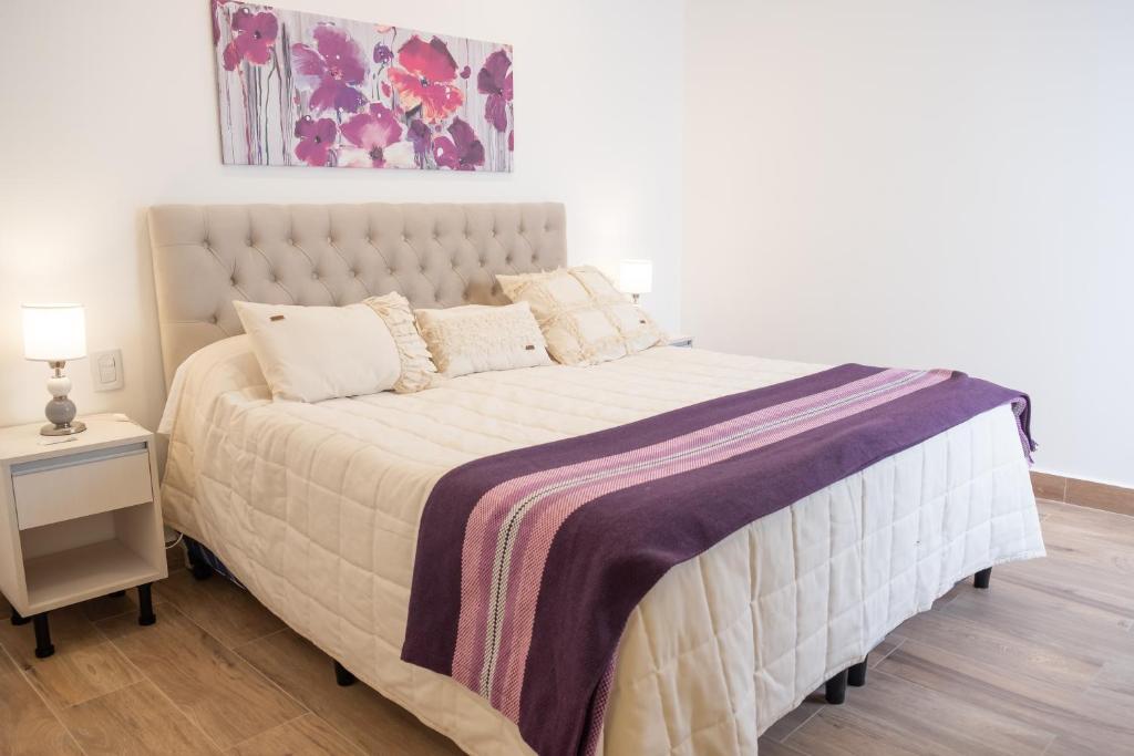 萨尔塔Augusta Deluxe的一间卧室配有一张大床和紫色毯子
