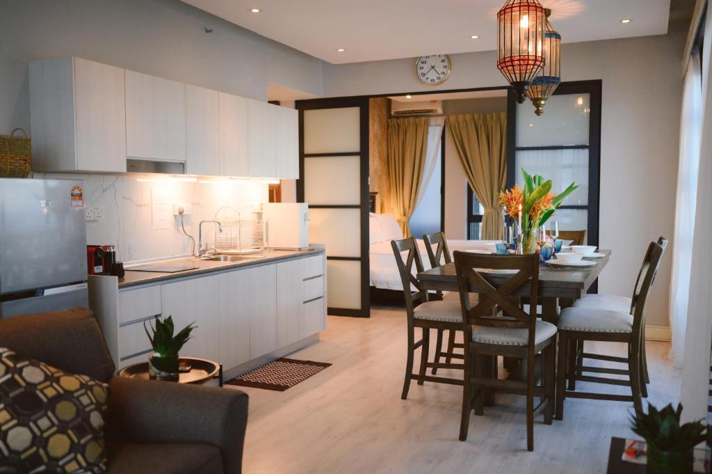 哥打京那巴鲁Petronella Suites Apartment @ Jesselton Quay的厨房以及带桌椅的起居室。