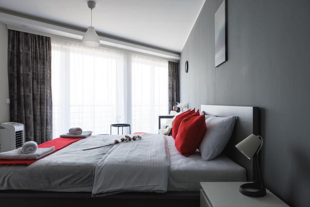 哥鲁拜克Horizont Dedine的一间卧室配有一张带红色枕头的大床和窗户