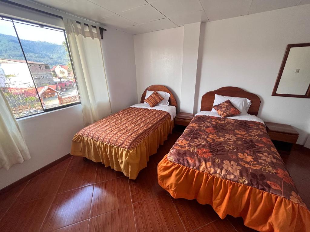 奥克萨潘帕Hospedaje Familiar Laos的带窗户的客房内的两张床