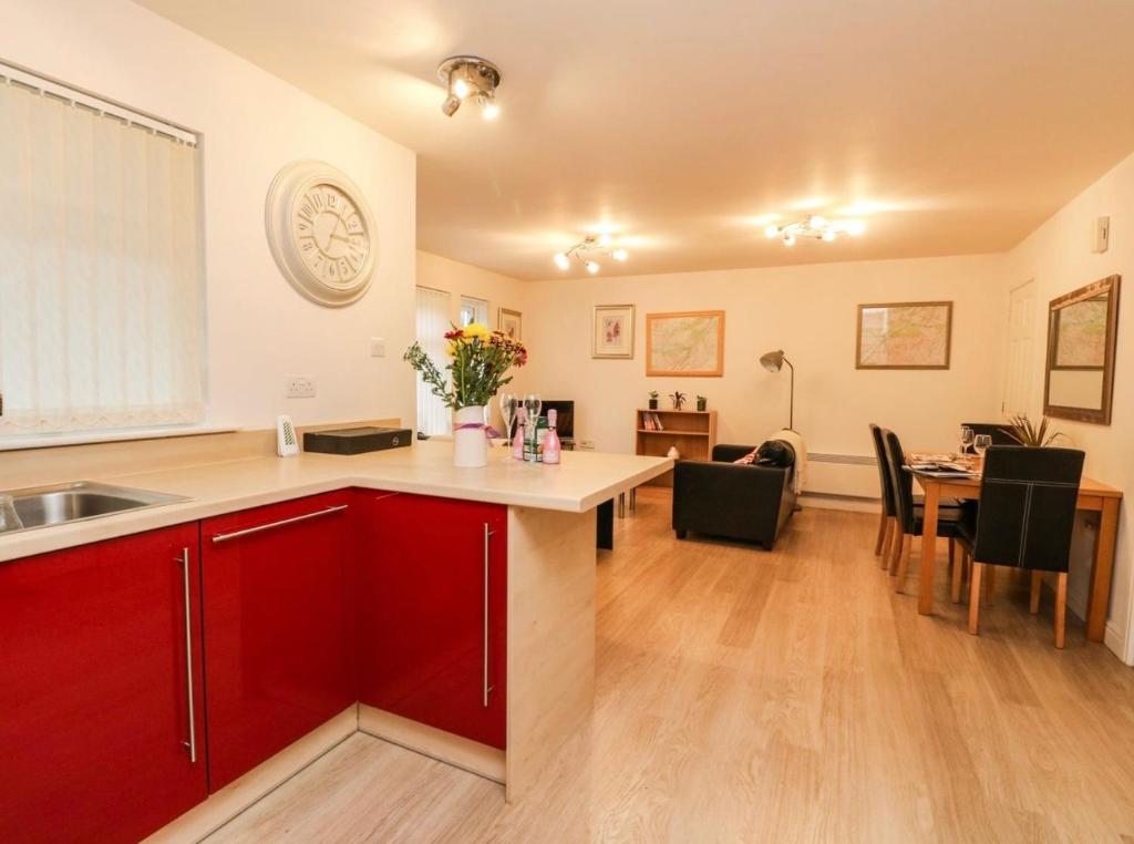 伊文格瑞SCOTTISH HIGHLANDS Superb 2 bedroom apartment.的一间带红色橱柜的厨房和一间用餐室