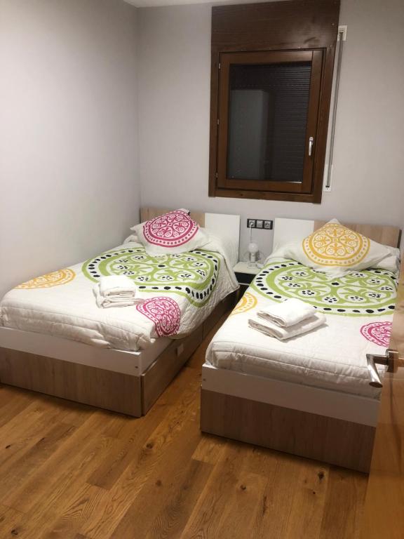 索特Precioso apartamento con piscina, ideal familias!的带镜子的客房内的两张单人床