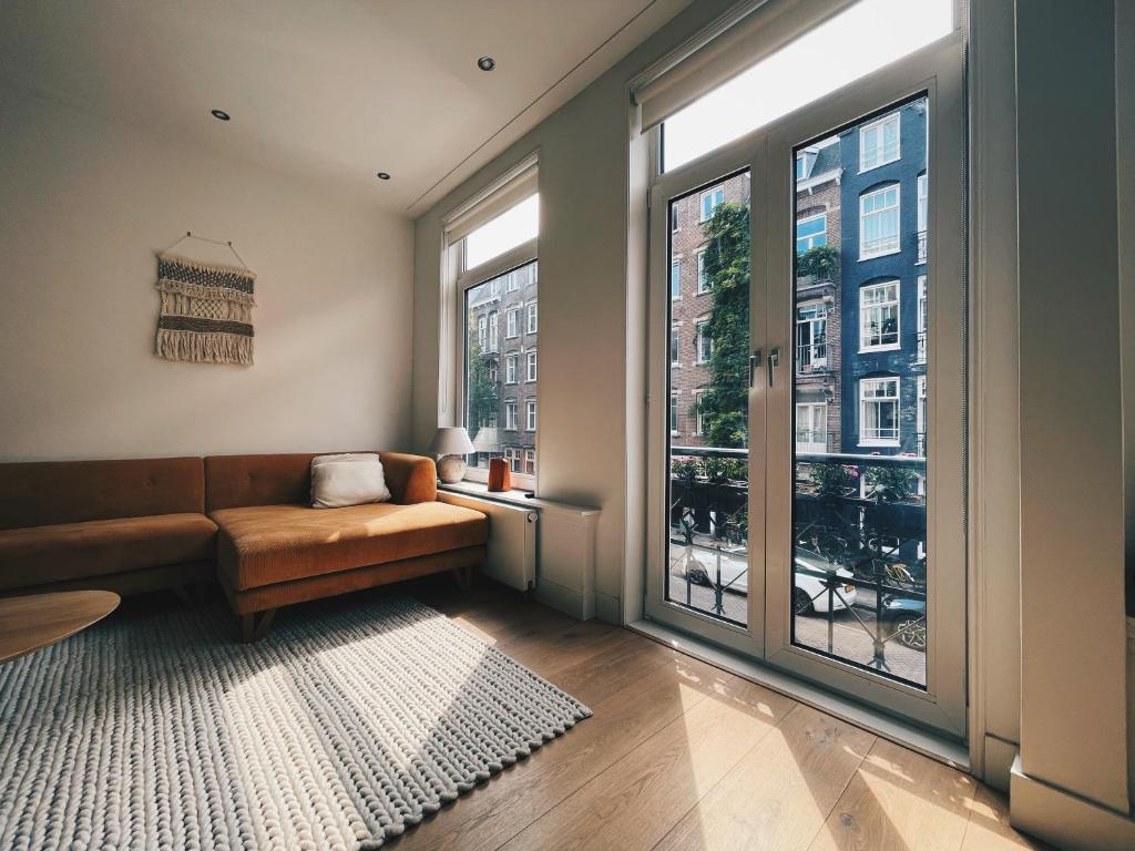 阿姆斯特丹Spacious Designer Duplex next to Central Park的带沙发和大窗户的客厅