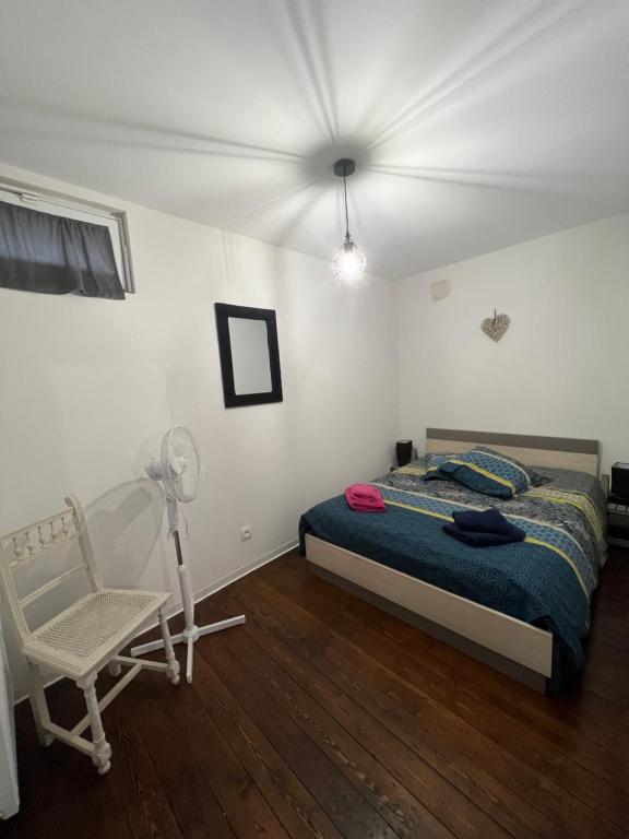 鲁法克Chez Ben et Maé的一间卧室配有一张床、一把椅子和风扇