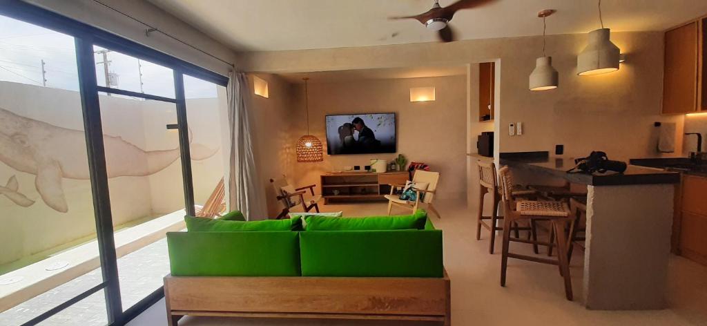 拉巴斯MANGLITO MANILA的一间带绿色沙发的客厅和一间厨房