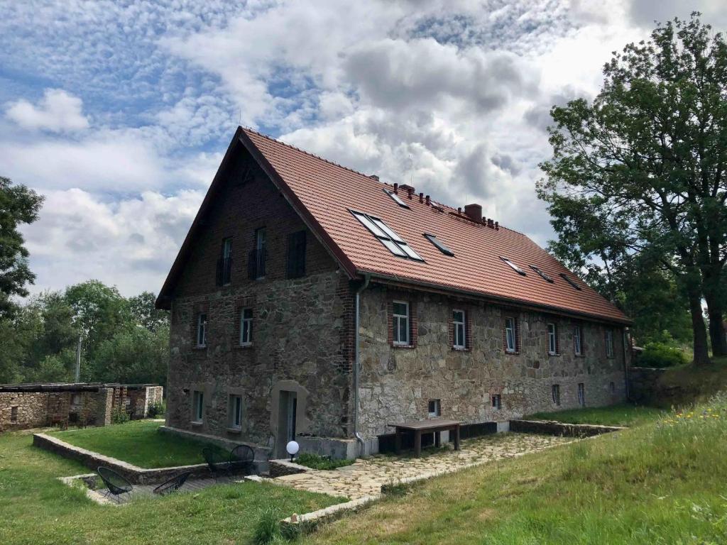 MałaKamienica80 Butikowa agroturystyka w Górach Izerskich的一座红色屋顶的古老石头建筑