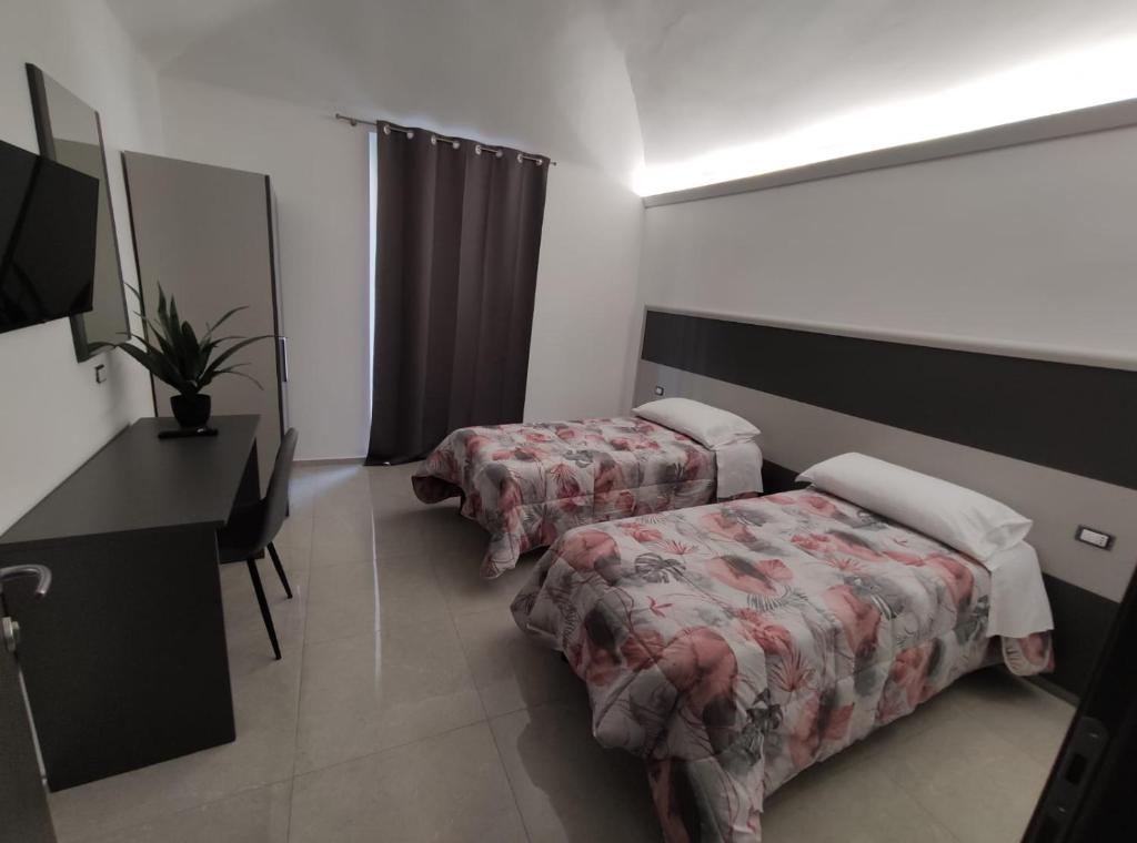 诺瓦拉Novara的客房设有两张床、一张桌子和一面镜子。