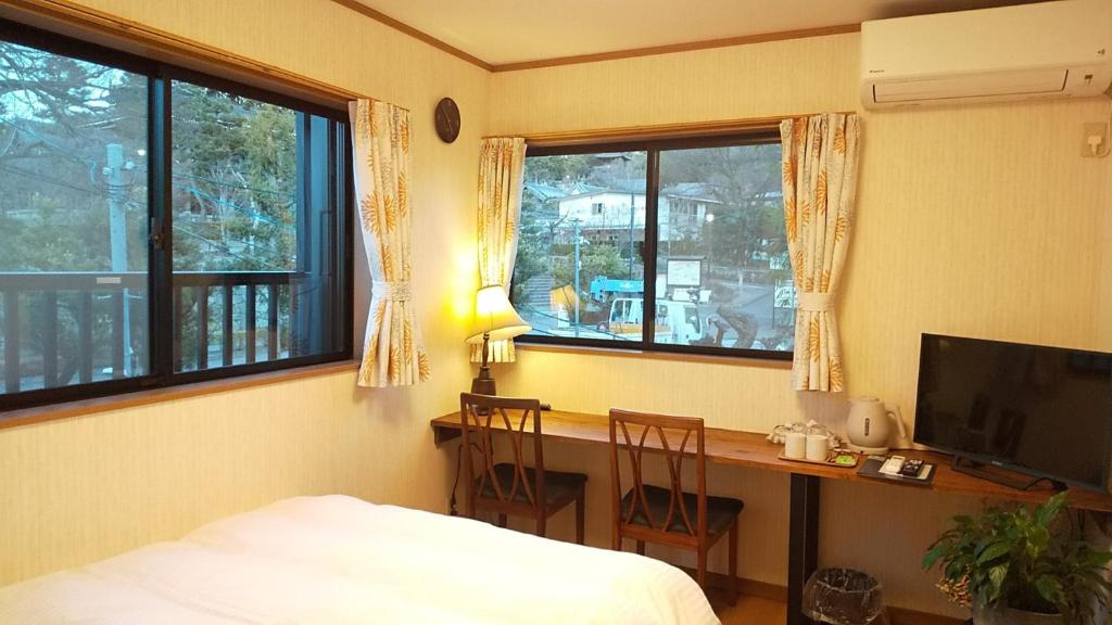 京都Guest House Nishimura - Vacation STAY 13436的一间卧室配有一张桌子和一张床,一张桌子和椅子