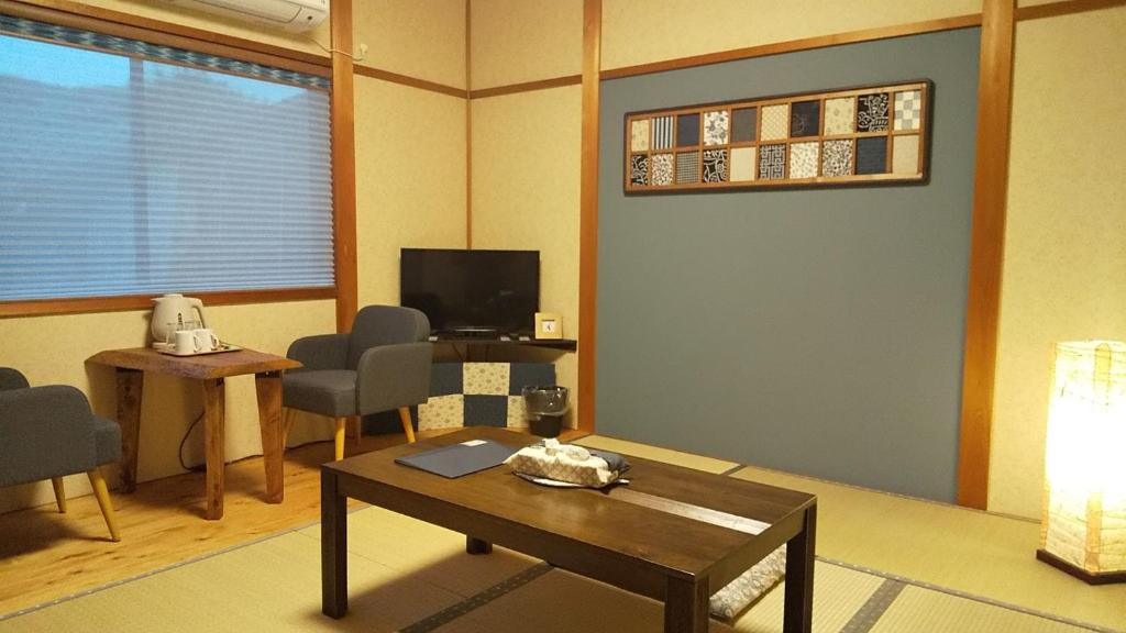 京都Guest House Nishimura - Vacation STAY 13438的客厅配有桌子和电视