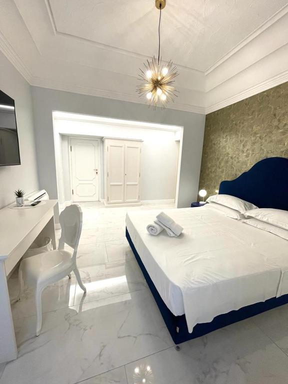 阿拉西奥Casa Balzola - Suite Astra的白色卧室配有床、书桌和桌子