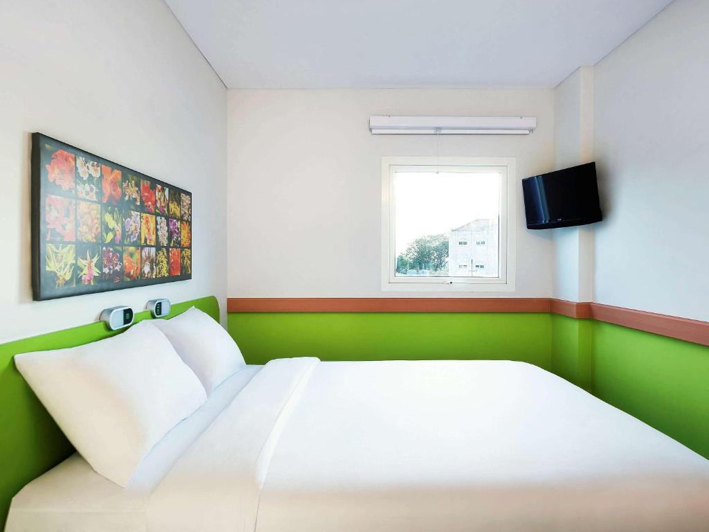 三宝垄Ibis Budget Semarang Tendean - CHSE Certified的卧室配有白色的床和窗户。