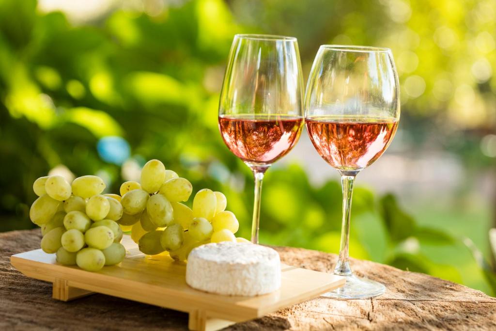PalmillaHotel Viña Kankura的木桌旁放两杯葡萄酒和葡萄