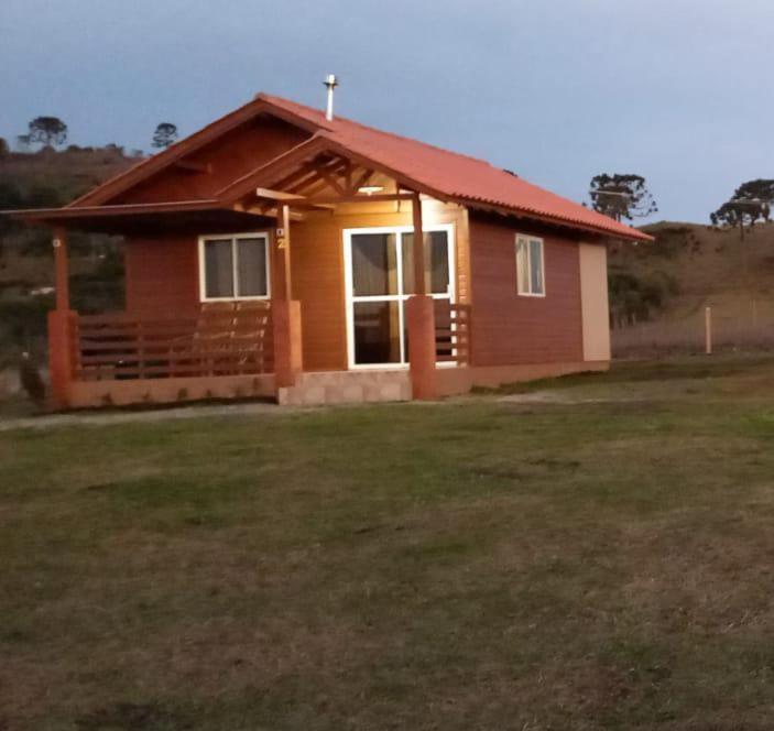 Mundo NovoCabana Campinho II的田野上带红色屋顶的小房子