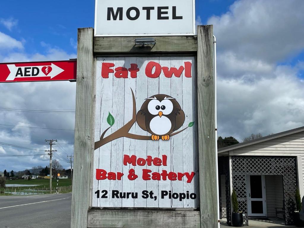 PiopioFatOwl Motel, Bar & Eatery的一家餐馆的标志,有汽车旅馆的标志