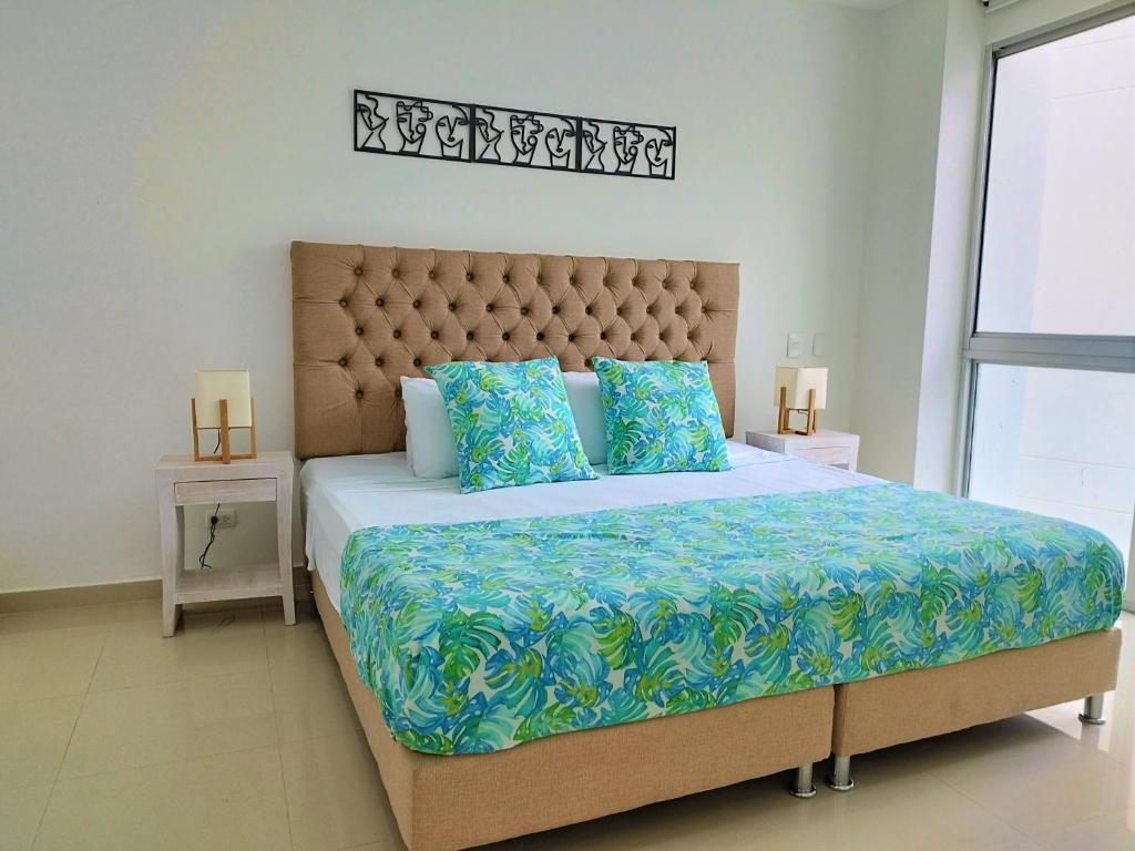 卡塔赫纳Morros Epic的一间卧室配有一张带蓝色枕头的大床