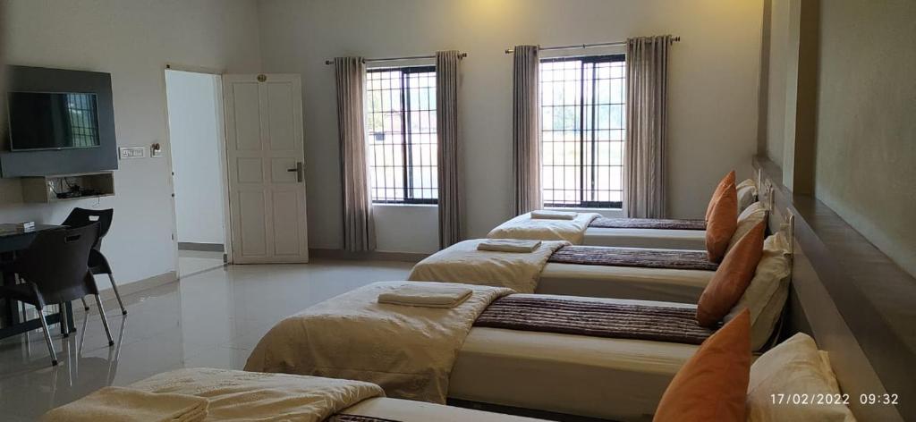 尼杜巴塞莱Alfa Inn的客房设有四张床、书桌和两个窗户。