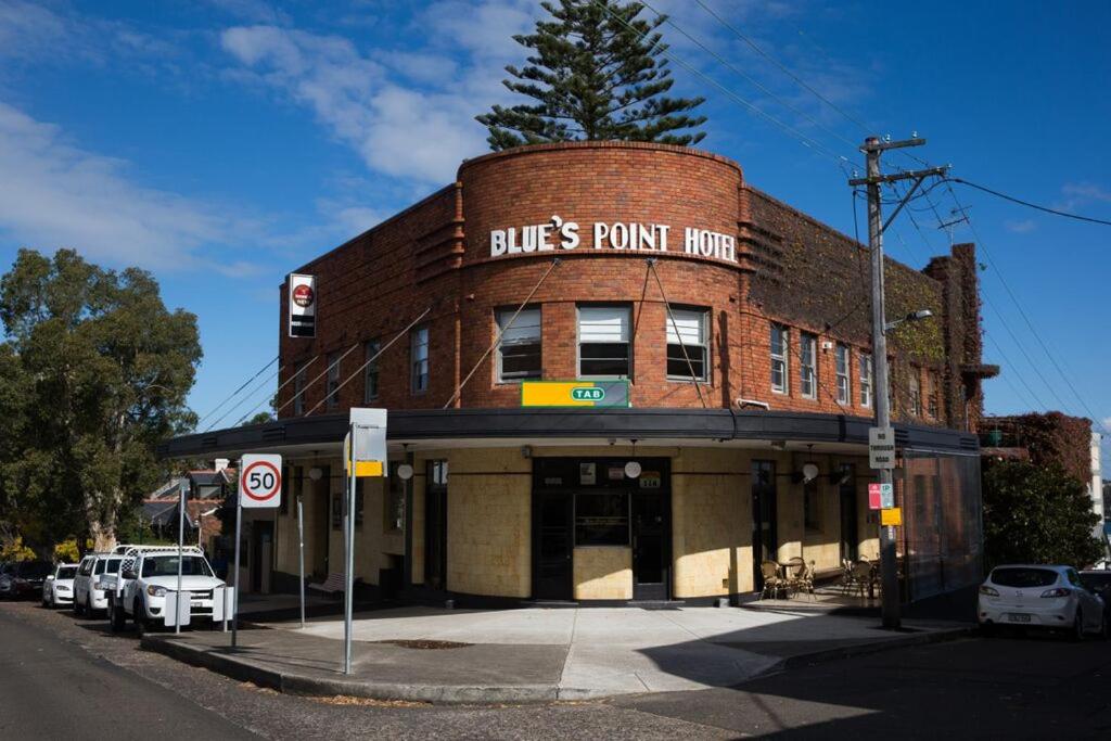 悉尼Blues Point Hotel的一座砖砌建筑,上面有蓝点的标志
