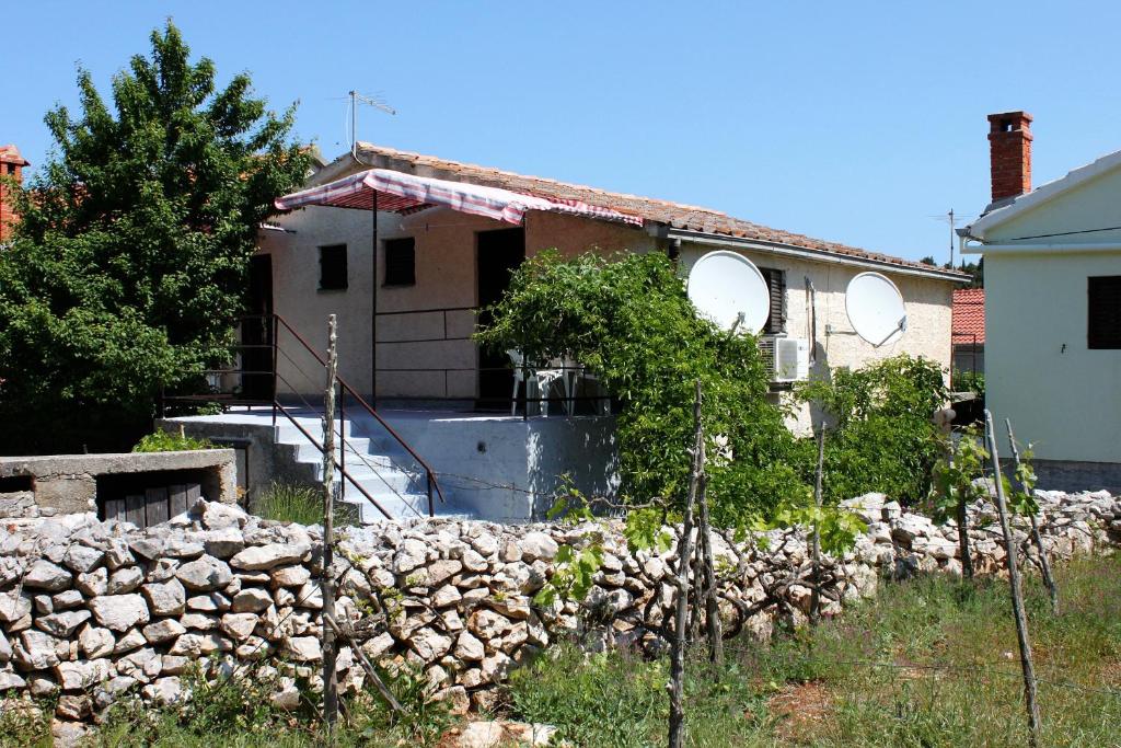 马里伊兹Holiday apartments Veli Iz, Iz - 6253的前面有石墙的房子