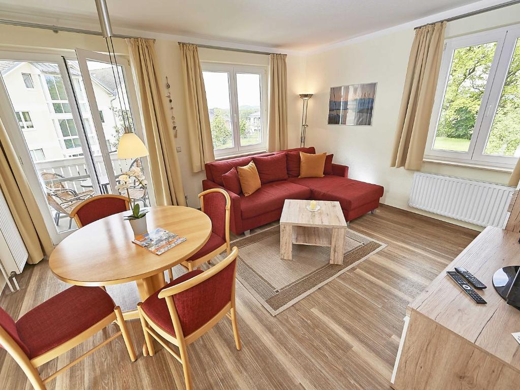 宾茨Wohnpark Stadt Hamburg - Apt. 04的客厅配有红色的沙发和桌子