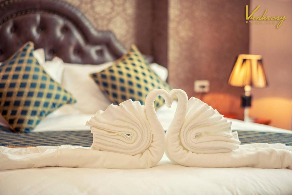 万象VANHSENG BOUTIQUE VIENTIANE HOTEL的床上用毛巾制成的两天鹅