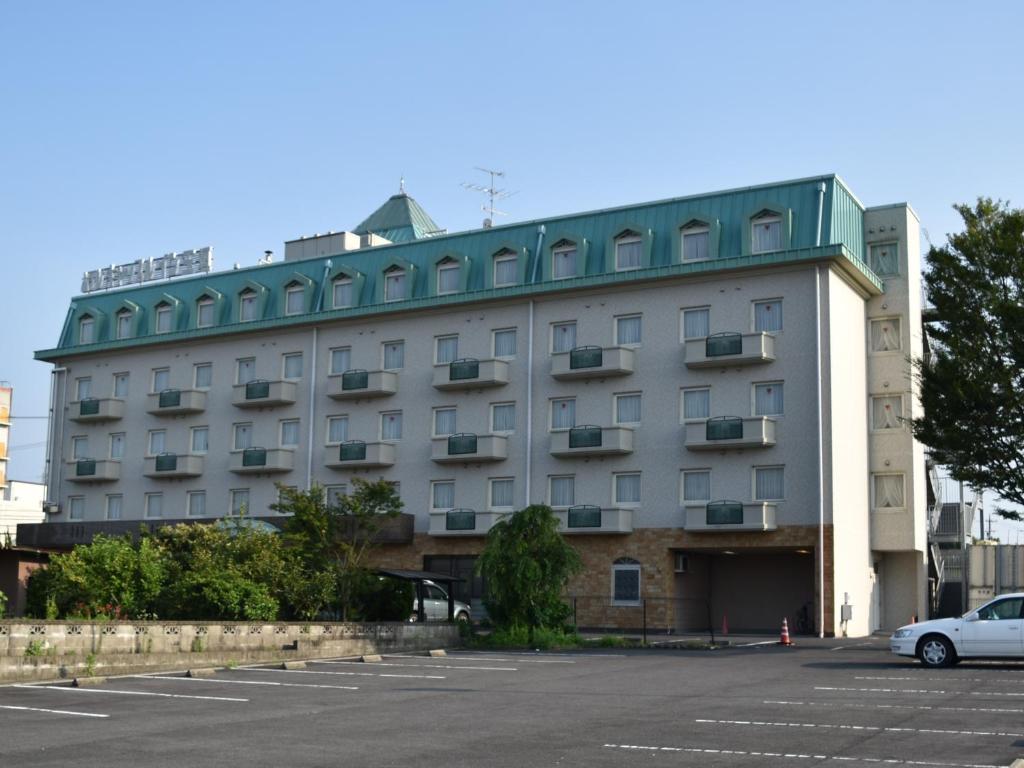 铃鹿市Hotel Castle Inn Suzuka Chuo的停车场内有停车位的建筑物
