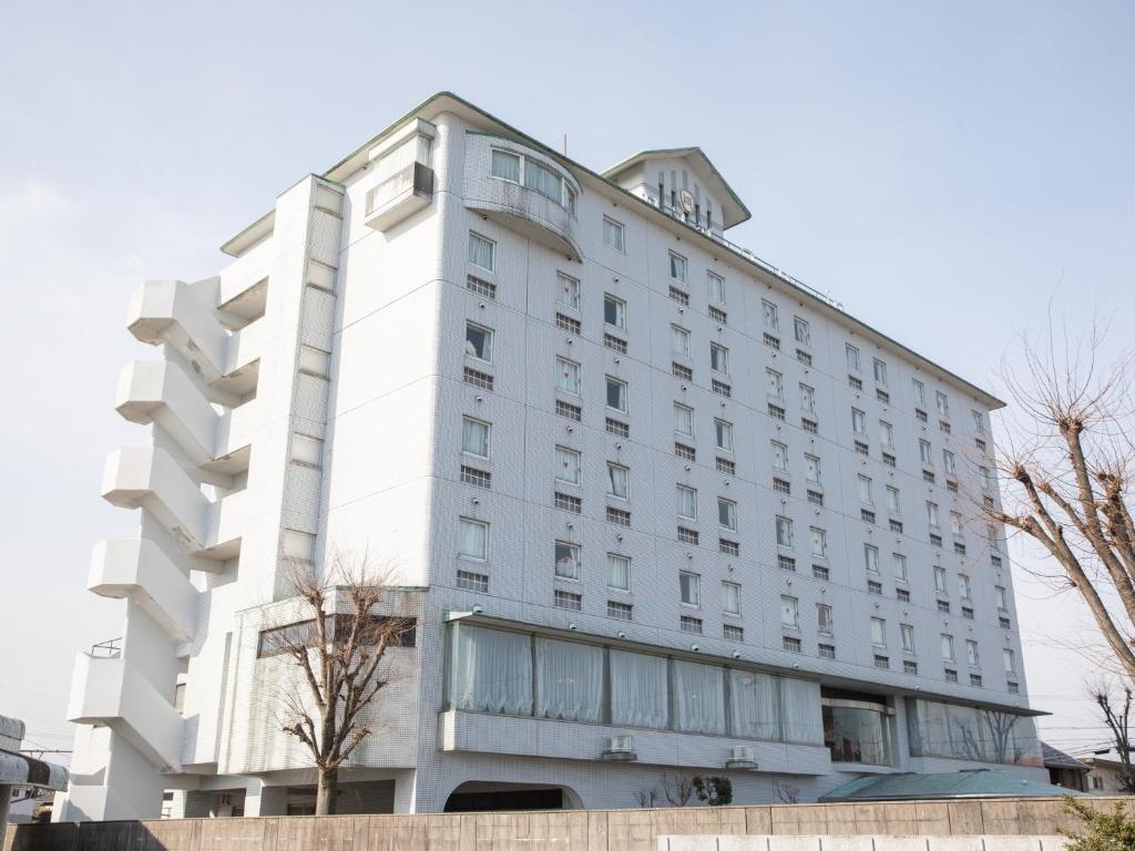 四日市Hotel Castle Inn Yokkaichi的一座白色的大建筑,有很多窗户