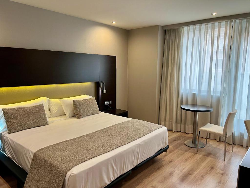 格拉纳达Hotel Tent Granada的酒店客房设有一张大床和一张桌子。