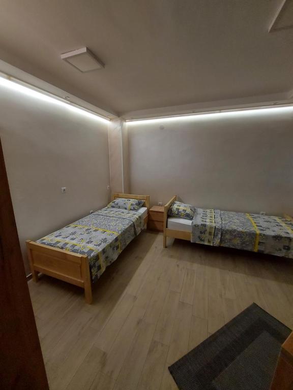 LukovoSTIV Apartmani的墙上灯的房间里设有两张床