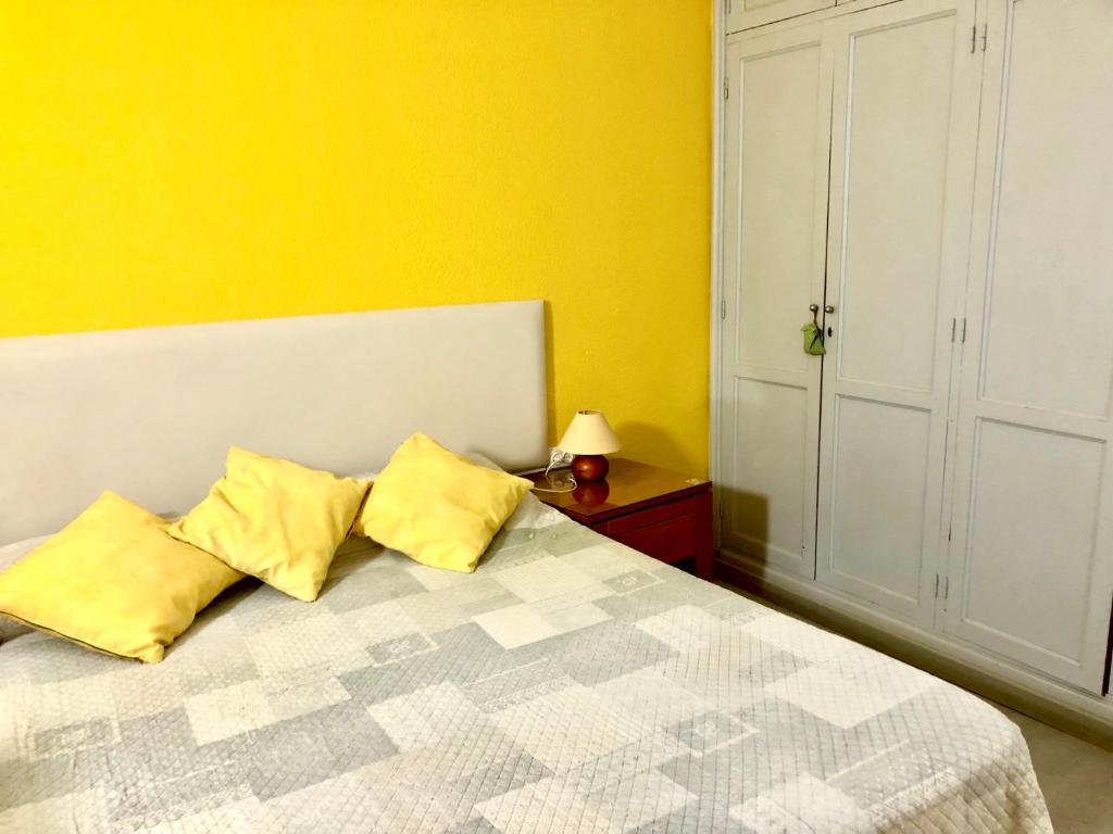 阿坎提拉德洛斯基Estudio privado in Los Gigantes的一间卧室配有一张带两个黄色枕头的床