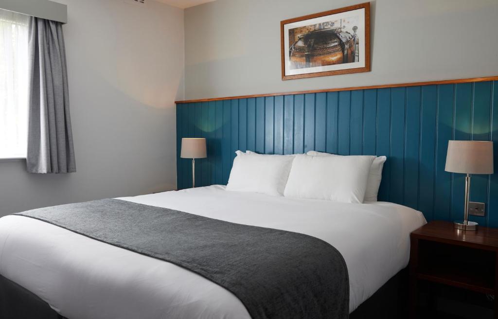 纽尼顿The Longshoot的一间卧室设有一张蓝色墙壁的大床