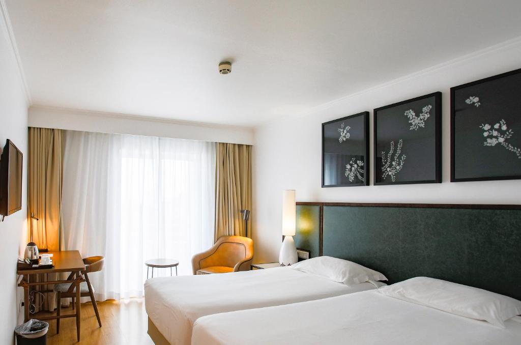 蓬塔德尔加达蓬塔德尔加达酒店的酒店客房设有两张床和一张桌子。
