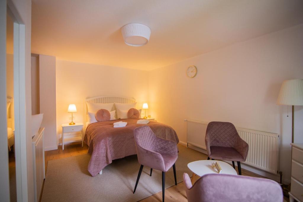 塞布尼茨ApartOne Land-Hotel的一间卧室配有一张带两把椅子和一张桌子的床。