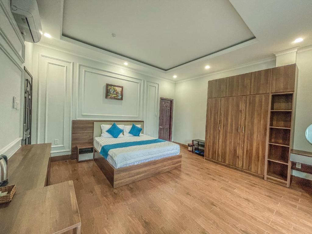Bến CátKhách sạn Hoàng Minh Châu Mỹ Phước的一间卧室配有一张带蓝色枕头的床。