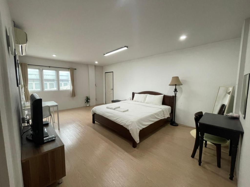 清迈清迈旅馆的一间卧室配有一张床、一张书桌和一台电视