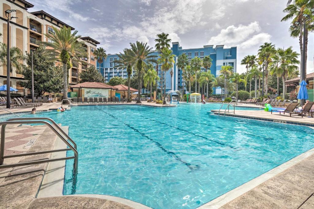 奥兰多Floridays Resort Condo Less Than 4 Mi to Walt Disney!的一座棕榈树和建筑的大型游泳池
