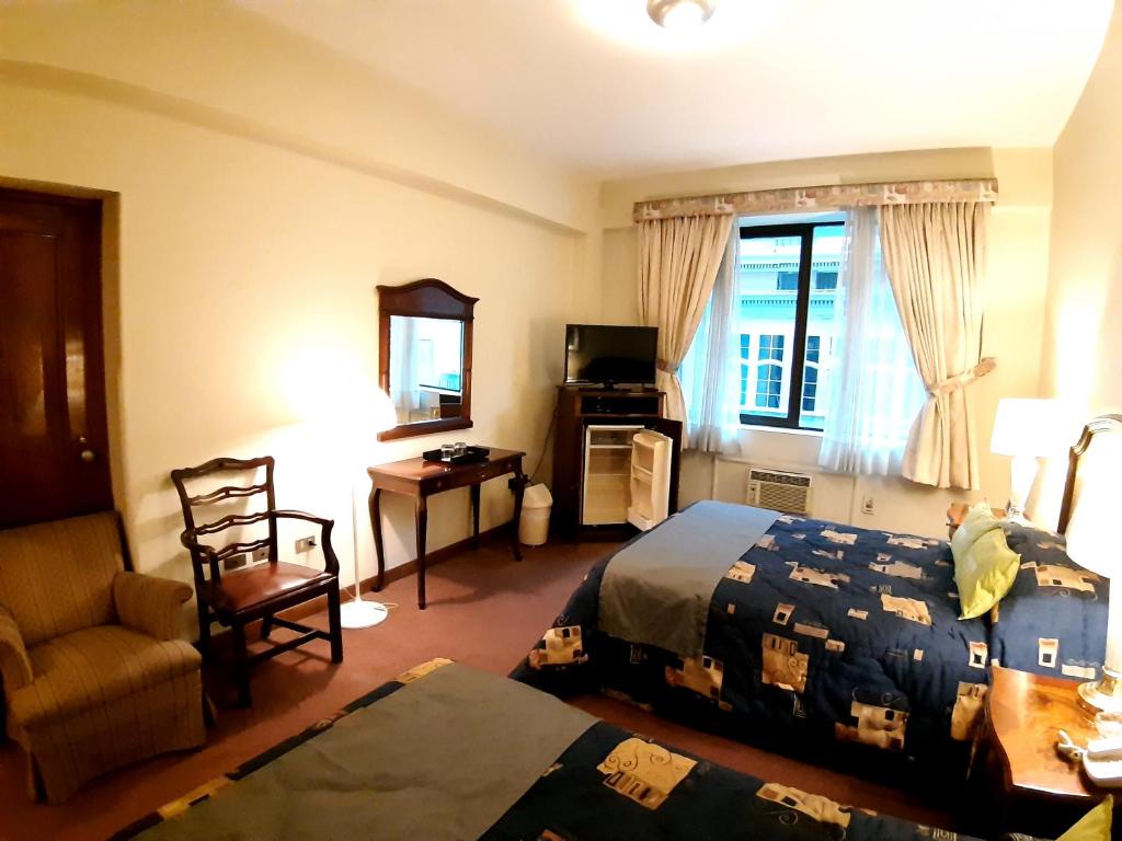 利马Hotel MAURY的配有一张床和一把椅子的酒店客房
