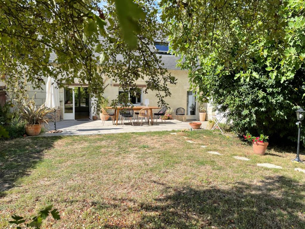 VillebernierChambres d hôtes avec Piscine et Spa La Folière Saumur的房屋前带桌椅的院子