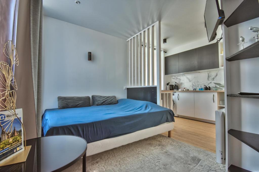 曼特农Le CoCoN de MaiNteNon的一间设有蓝色床和厨房的小卧室