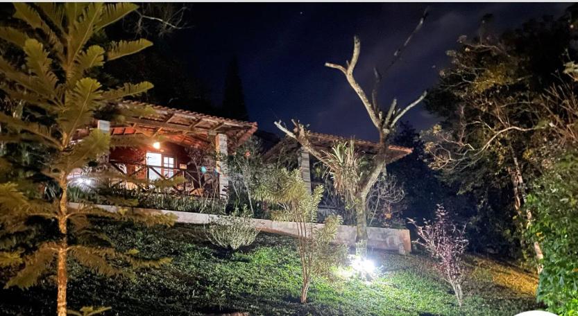瓜拉米兰加Chalé romântico , rústico e vista de tirar o fôlego的夜晚的房子,前面有灯