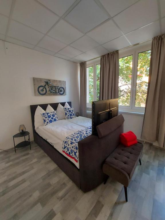 维也纳Apartman Favorita的一间卧室配有一张床、一把椅子和窗户。