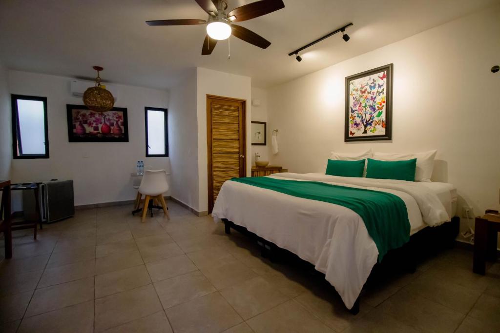 坎昆Hotel Tequila Cancun的一间卧室配有一张大床和吊扇