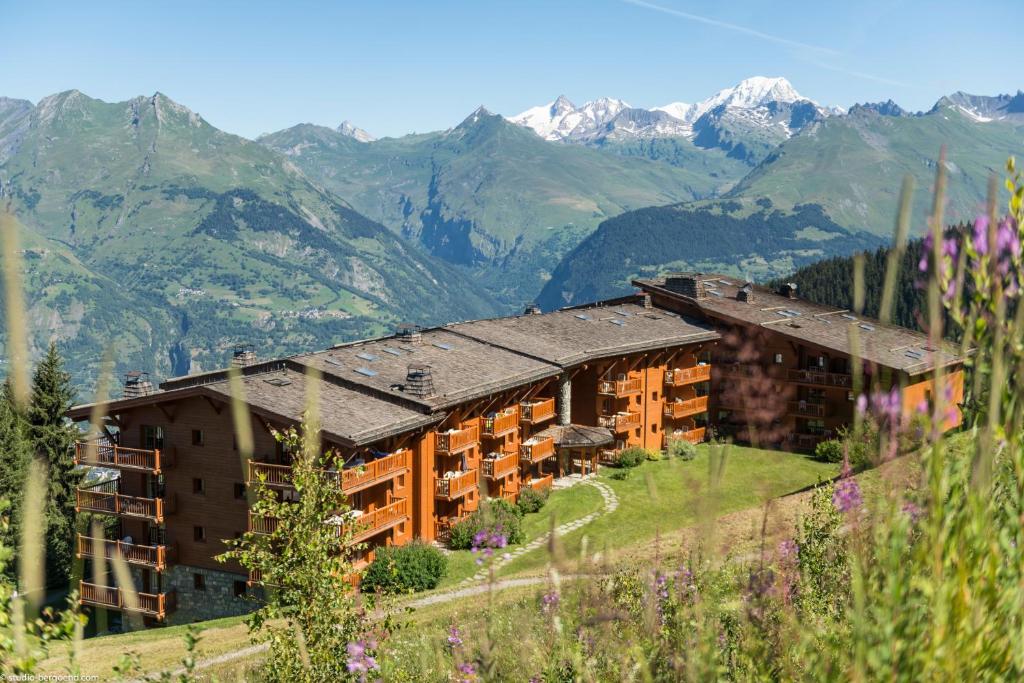 阿克1800Résidence Pierre & Vacances Premium Le Roselend的山丘上以山为背景的酒店