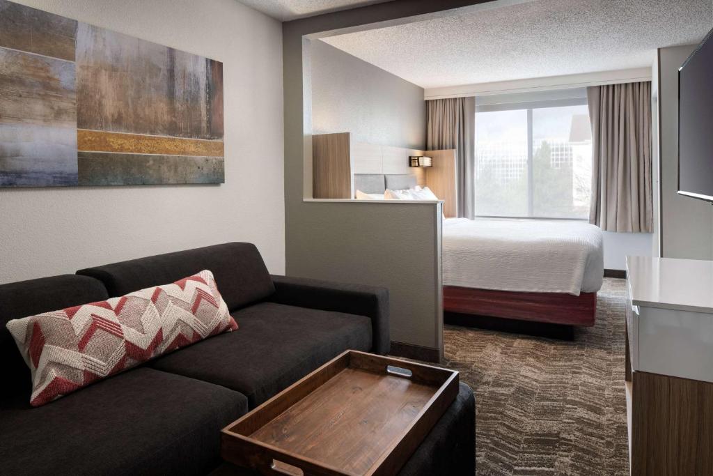 伦顿Sonesta Select Seattle Renton Suites的酒店客房设有一张沙发和一张床