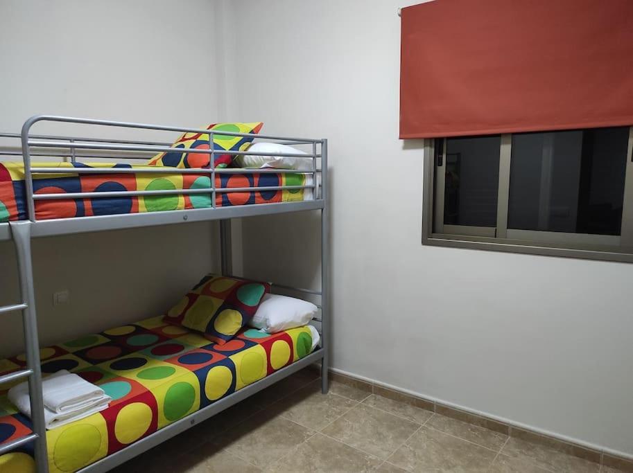 拉雷斯廷加VV LA ISLA的客房内的双层床和一张色彩缤纷的床