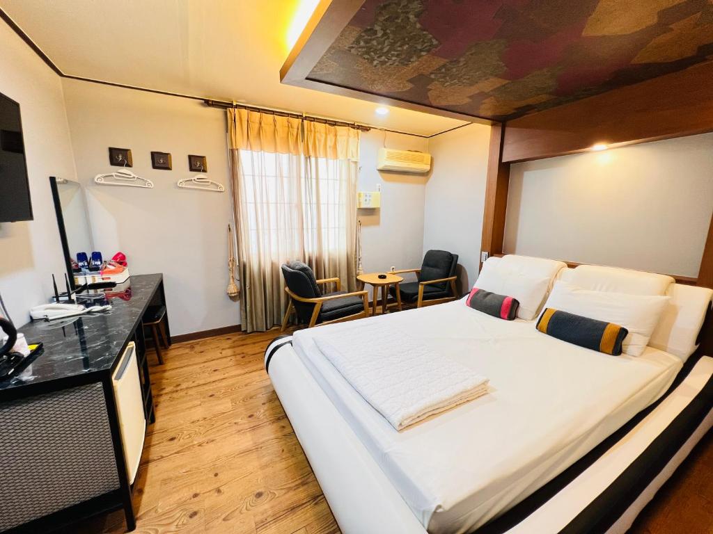 济州市Sweet Hotel的酒店客房设有一张大床和一张桌子。
