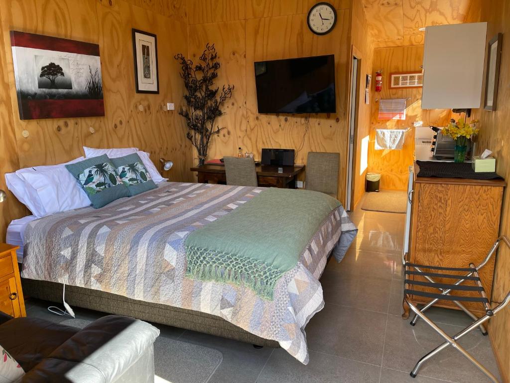 莫图伊卡Glenwai的一间卧室配有一张床、一张书桌和一台电视。