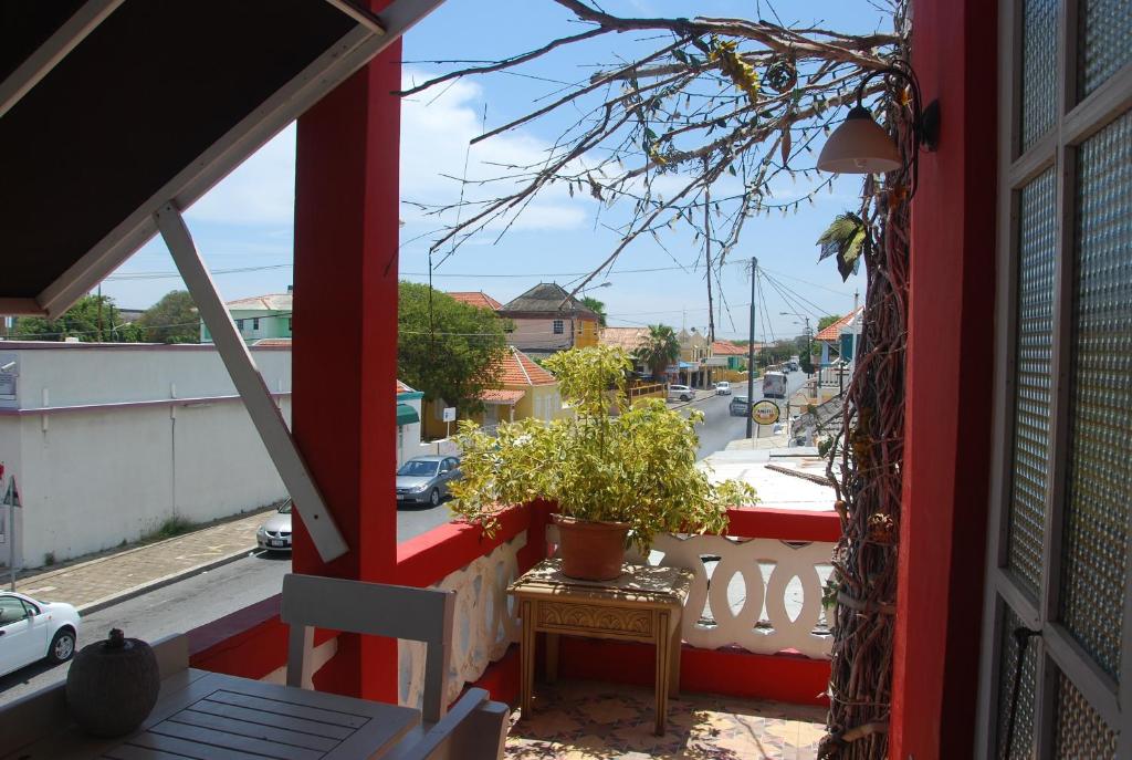 威廉斯塔德库拉索阿波罗尼亚精品度假屋的阳台,上面有桌子和盆栽植物