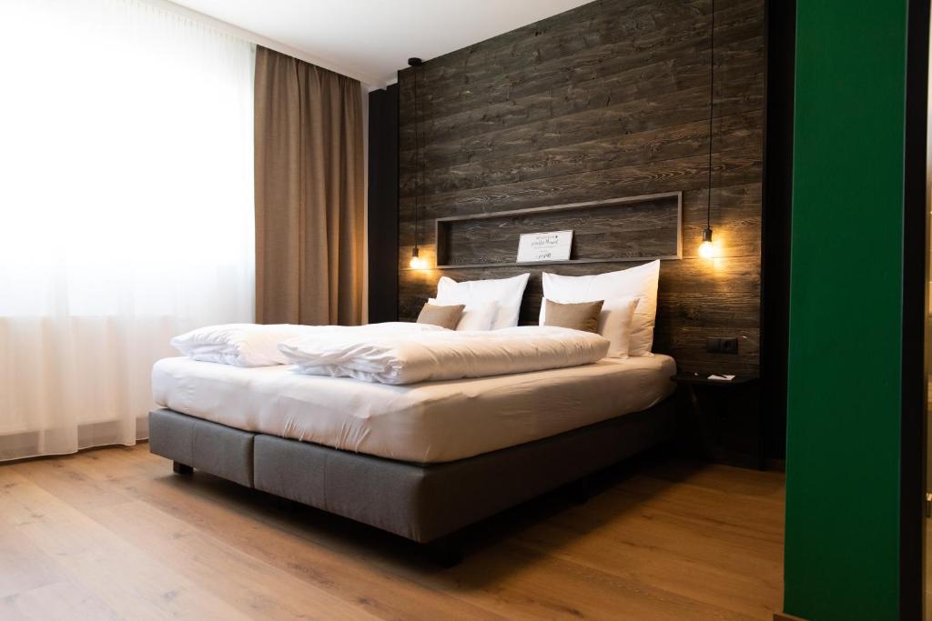 ZistersdorfSelf-Check-in Hotel VinoQ Zistersdorf的一间卧室设有一张带木墙的大床