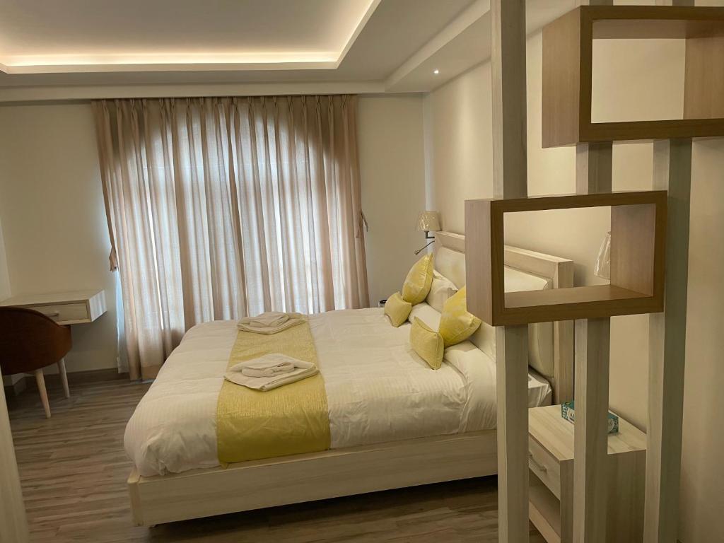 加德满都Palmo Holiday Apartments的一间卧室配有一张带黄色枕头的床和一扇窗户